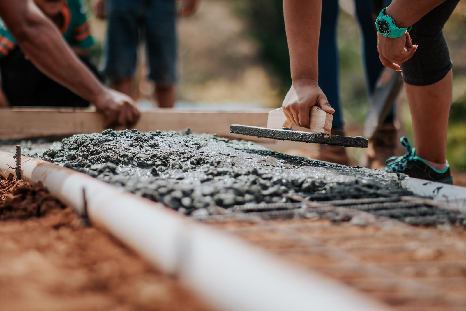 A crew finishing a concrete and steel site detail