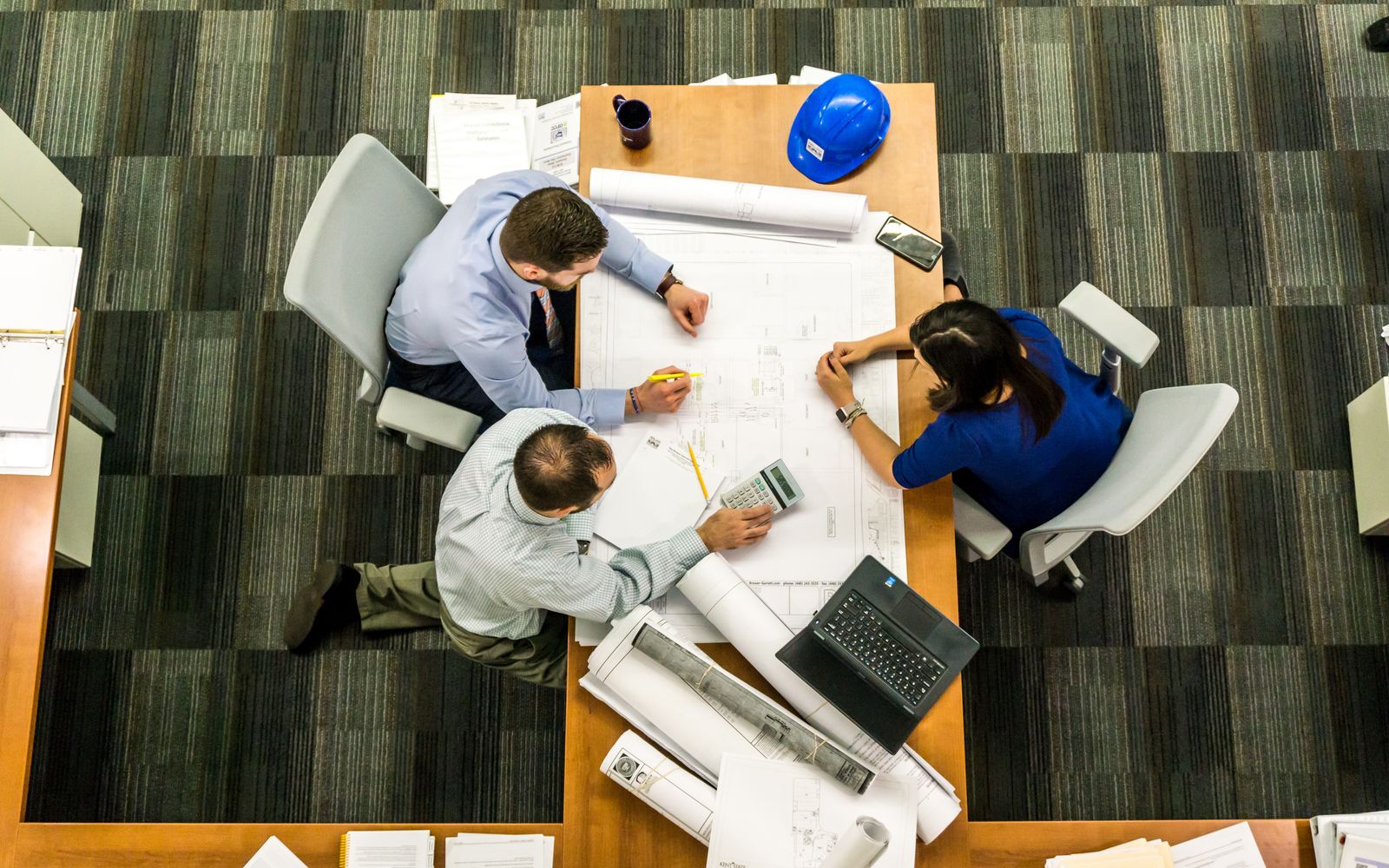 People reviewing technical drawings